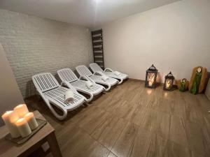 Una habitación con cuatro camas blancas en una habitación con una pared de ladrillo. en BIESZCZADZKI RAJ Komfortowe domy z kominkami i Sauną na obiekcie, en Olchowiec