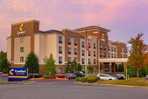 Un hotel con coches aparcados en un estacionamiento. en Comfort Suites Little Rock West, en Little Rock