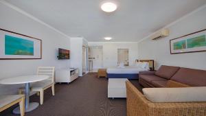 a hotel room with a couch and a bed at Vista Mare - Beachside Studio With Stunning Views in Ettalong Beach