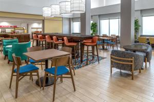 a dining room with tables and chairs and windows at Hampton Inn and Suites Coconut Creek in West Dixie Bend