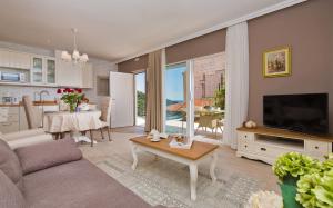 sala de estar con sofá, TV y mesa en Villa Boban en Dubrovnik