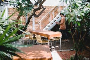 a man standing on a ladder next to a staircase at THE GOOSE HOUSE UBON in Ubon Ratchathani