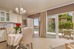 eine Küche und ein Esszimmer mit einem Tisch und einer Vase aus Blumen in der Unterkunft Villa Boban in Dubrovnik