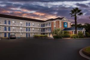 an exterior view of a hotel with a parking lot at Suburban Studios Stuart near Federal Hwy 1 in Stuart
