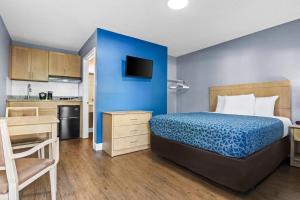 a bedroom with a bed and a blue wall at Suburban Studios Stuart near Federal Hwy 1 in Stuart