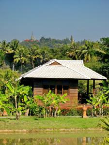 a small wooden house in the middle of a field at Baan Chai Thung Resort in Doi Saket