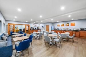 a restaurant with tables and chairs and a kitchen at Comfort Inn Rhinelander in Rhinelander