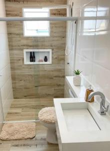 a bathroom with a shower with a toilet and a sink at Vila jequitimar in Guarujá