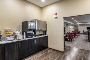 a kitchen with a counter and a cafeteria with tables at Comfort Suites Brunswick - Cleveland Southwest in Brunswick