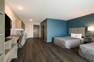 a hotel room with two beds and a kitchen at WoodSpring Suites Knoxville West in Knoxville +33 photos