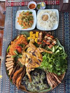 a plate of food with meat and vegetables and rice at Phong Nha Ecolodge Homestay & Tours - Mountain View in Phong Nha