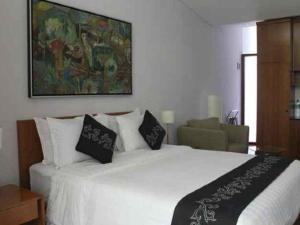 a bedroom with a large white bed with black pillows at VillaTel Salse in Bandung +215 photos