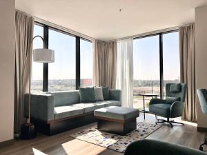 a living room with a couch and a large window at Cambria Hotel Northlake Conference Center - Roanoke in Northlake
