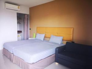 una camera da letto con un letto grande con lenzuola bianche di The Lofts Eco Resort a Nakhon Ratchasima