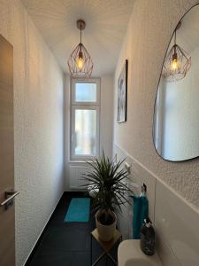 a bathroom with a potted plant and a mirror at Apartment Stadtperle in Gotha +43 photos