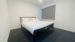 a bed in a white room with a window at Residence Of Frankcom in Blackburn