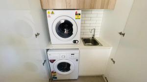 a washing machine and a sink in a laundry room at Residence Of Frankcom in Blackburn