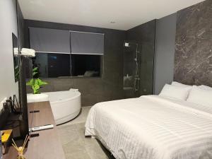 a bedroom with a large bed and a bath tub at HK Villa Resort in Bangkok
