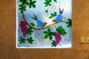 Una pintura de dos pájaros posados en una rama de uvas. en Green Tree House Villa Ubud, en Ubud