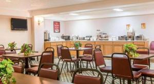un ristorante con tavoli e sedie e una cucina di Baymont by Wyndham Lake George a Lake George