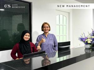 two women standing at a counter in a room at City Homestay in Miri