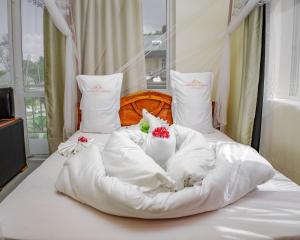 a bed with white sheets and flowers on it at Cashewnut Hotel in Mtwara