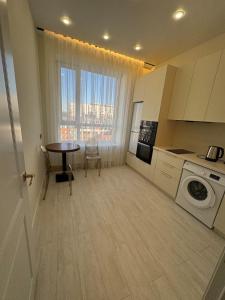 una piccola cucina con tavolo e una sala da pranzo di Dauir 2 a Astana