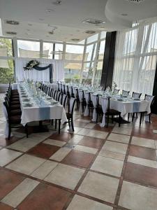 a large dining room with long tables and chairs at Amstel Hattyú Panzió -Érintésmentes bejelentkezés in Győr
