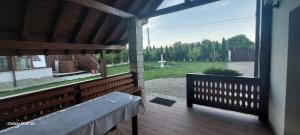 a porch with a bench and a view of a yard at Craii Neamtului in Almaş