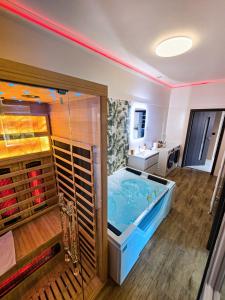 a bathroom with a large blue tub in a room at Lumina Wellness Apartman in Sátoraljaújhely