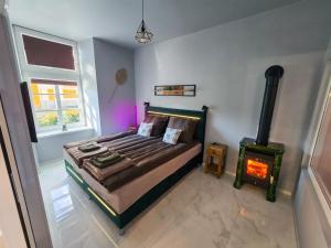 a bedroom with a bed and a wood stove at Lumina Wellness Apartman in Sátoraljaújhely