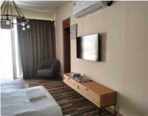 a hotel room with a bed and a tv on the wall at Desert Breeze Resort in Ras al Khaimah