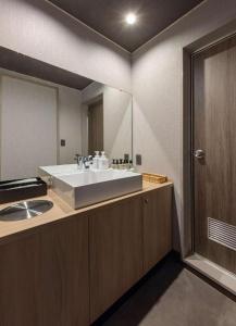 a bathroom with a sink and a large mirror at Higaki Hotel in Miya