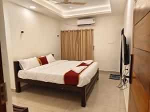 a bedroom with a bed and a flat screen tv at Kaarthik Residency in Puducherry