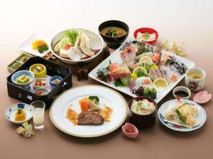 a table with plates of food and bowls of food at Ako Royal Hotel in Himeji