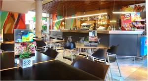un restaurante con mesas y sillas y un bar en AQUA Hotel Nostre Mar Apartments, en Pineda de Mar