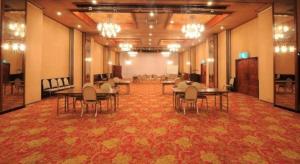 a large room with tables and chairs in a building at Inuyamakan in Inuyama
