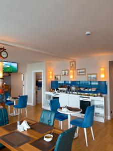un soggiorno con sedie blu e una cucina di Come a Lot Aparthotel Batumi a Batumi