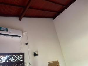 a room with a white wall and a wooden ceiling at Ryo hostel in Ahangama