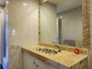 une salle de bain avec un lavabo avec un grand miroir dans l'établissement Dolphin Delight, à Bloubergstrand 51 autres photos