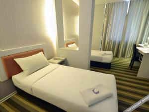 a hotel room with a white bed and a bathroom at First Residence Hotel Kemaman in Cukai