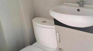 a bathroom with a white toilet and a sink at HOTEL BAJET MUGHOH SENGOTI in Kampung Raja