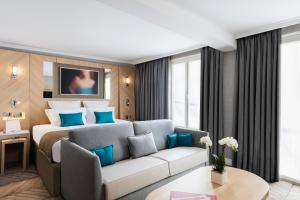 een hotelkamer met een bed en een bank bij Hotel Louvre Saint-Honoré in Parijs
