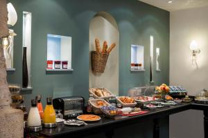 a buffet with food on a table in a room at Hotel Louvre Saint-Honoré in Paris