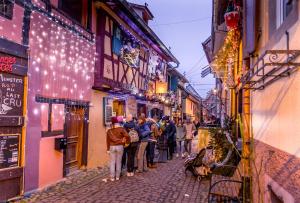 a group of people walking down a street at night at Camping ClicoChic Au Clair Ruisseau in Gerstheim