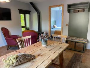 a room with a wooden table with chairs and a bedroom at Entrenogueras in Huerta del Marquesado +4 photos