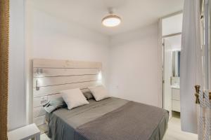 a bedroom with a bed with a wooden headboard at El Rincon de Marta in Las Palmas de Gran Canaria