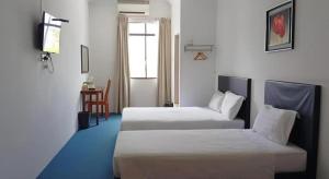 a hotel room with two beds and a table at OYO 90785 Pandan Hotel in Kota Kinabalu