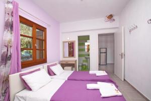 a bedroom with two beds and a window at Sklavos Studios skopelos in Neo Klima