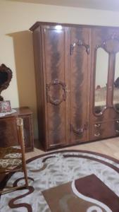 een kamer met een houten kast en een tapijt bij Alex Lux apartment in Glimboca